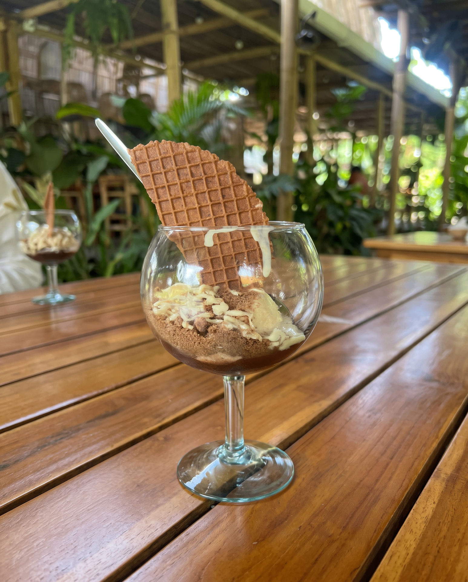 Postre De la Sierra Banana en copa de vidrio con galleta wafer