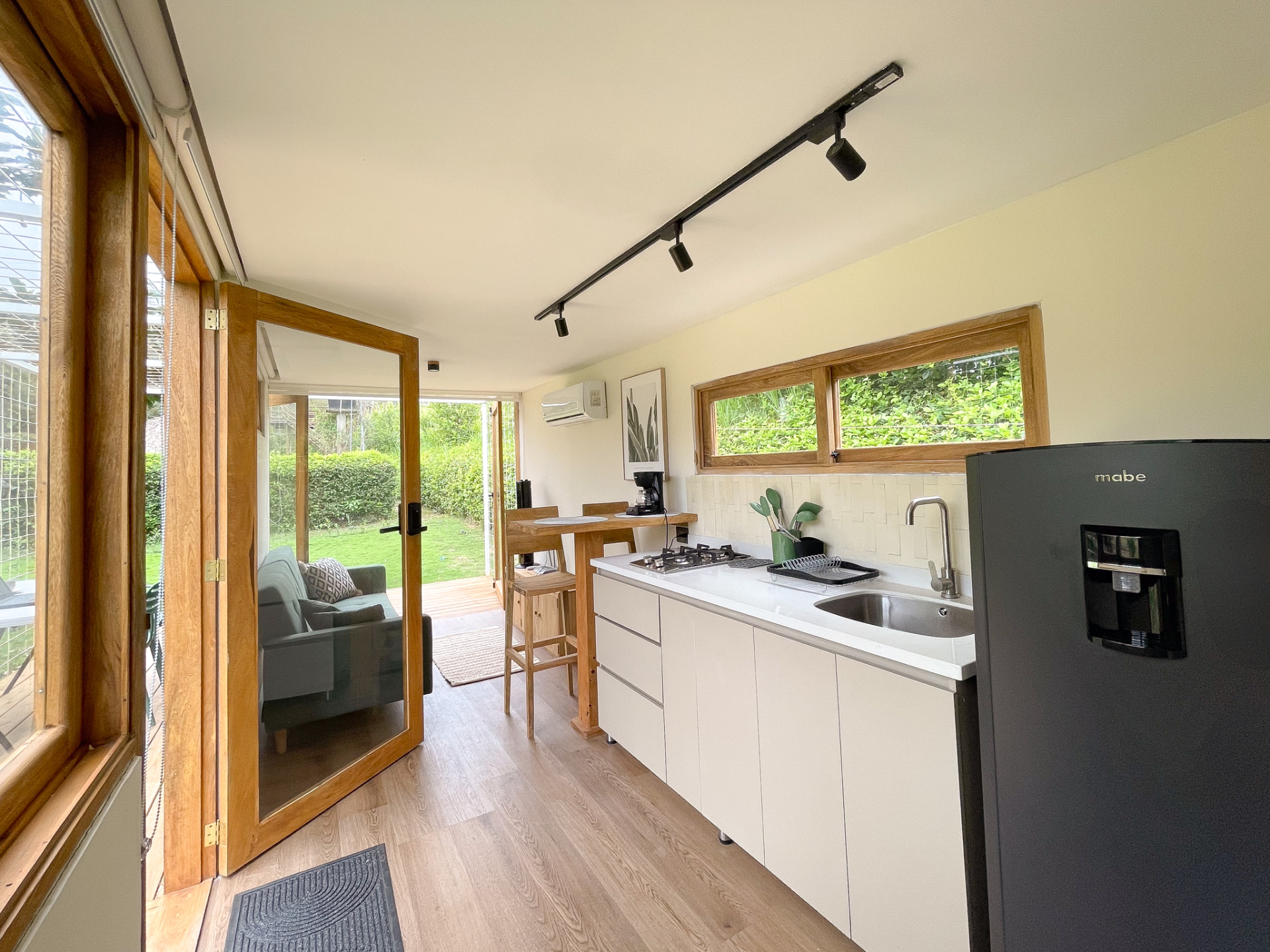 Interior de la Casa 1 con cocina y puertas abiertas al jardín