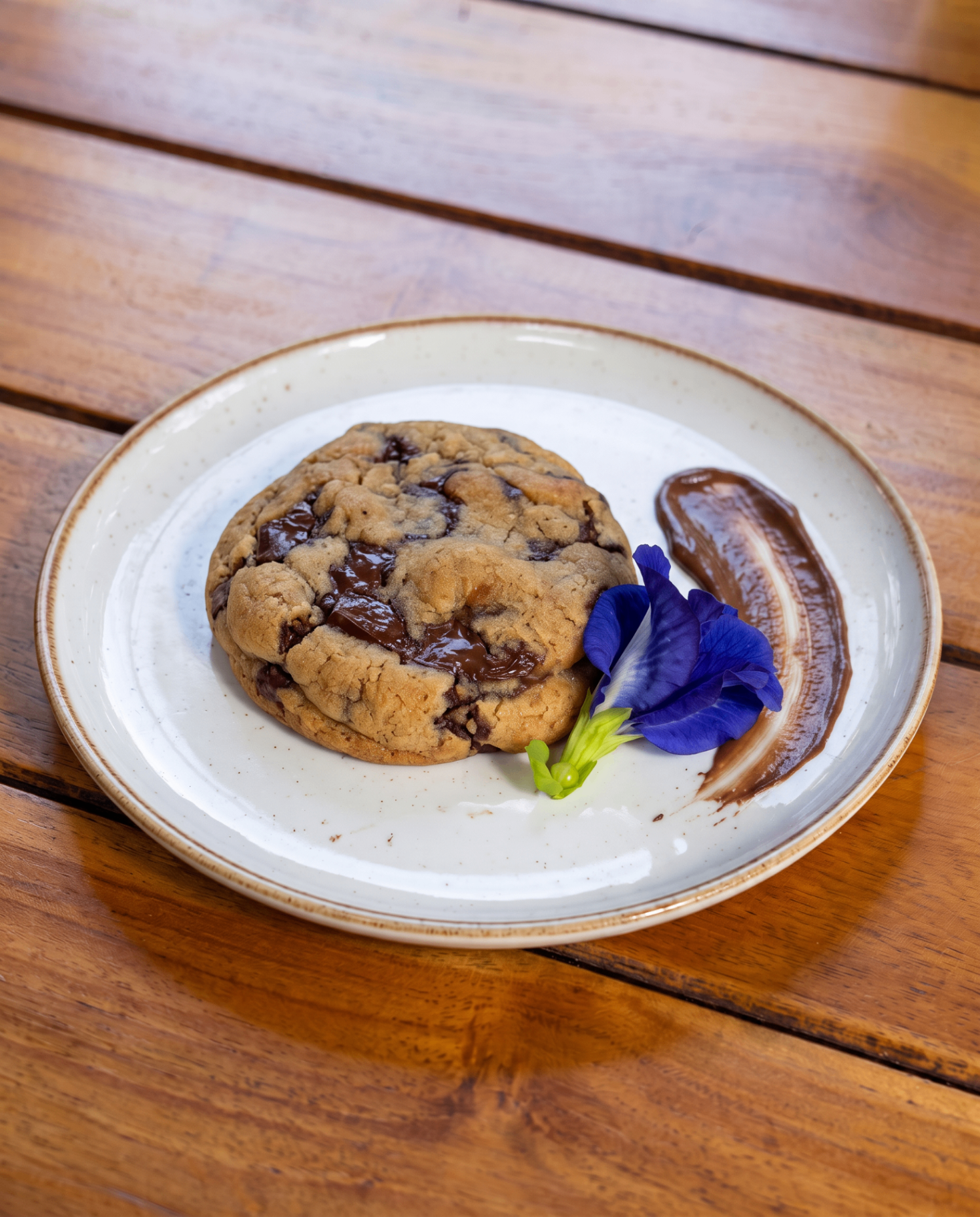 Galleta de la casa con chips de chocolate derretido y flor de clitoria