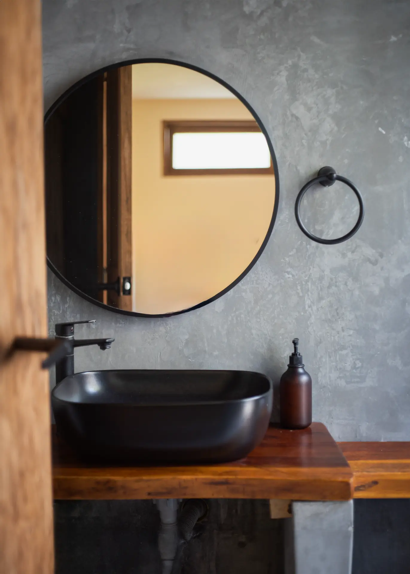 Baño de la Casa 2 con lavamanos negro y mesón de madera