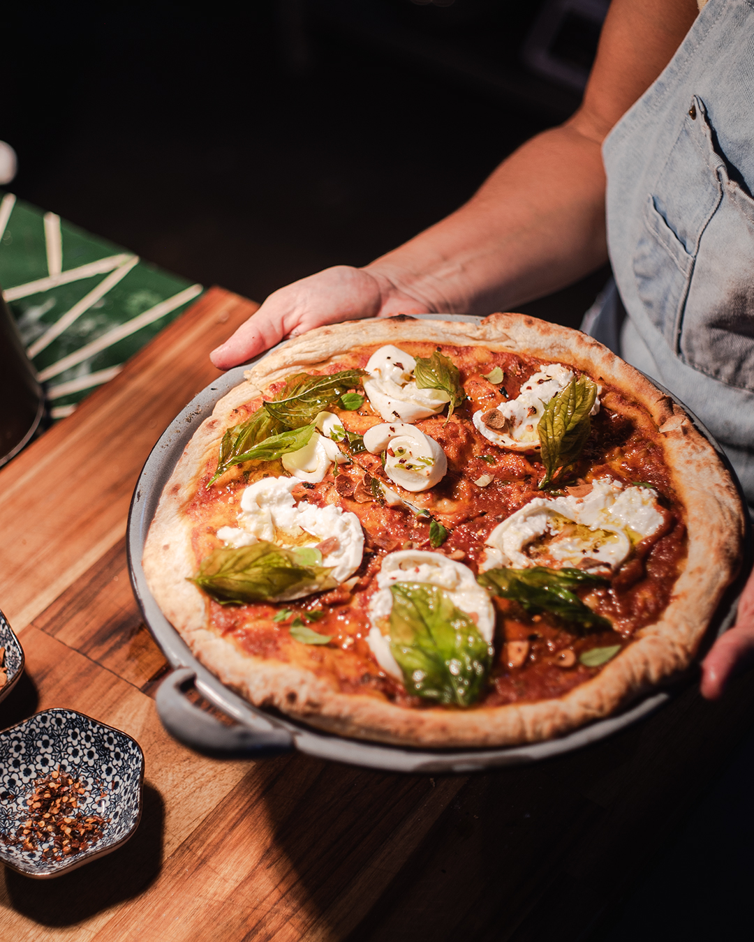 Pizza Amor es rosa con burrata, albahaca y peperoncino.